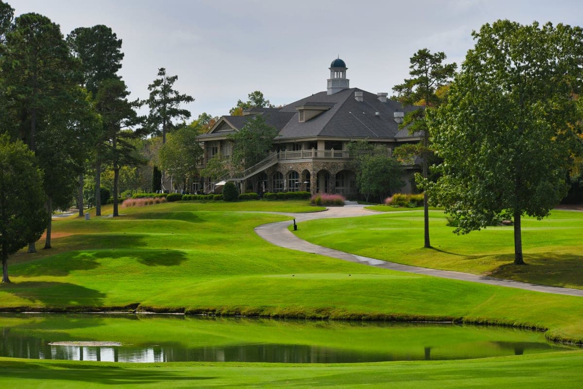 Golf course with green grass field near body of water